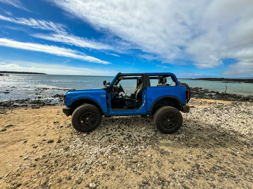 A blue Bronco parked on the shore in Maui for a private Maui tour